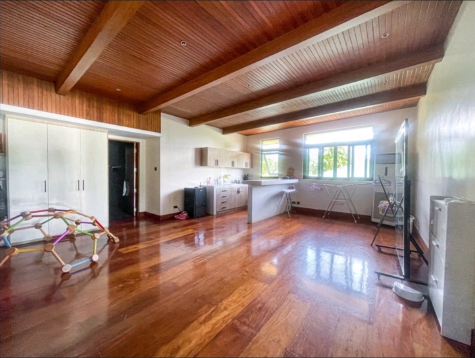 Attic room with exposed wood beam ceiling, kitchenette and hardwood floors