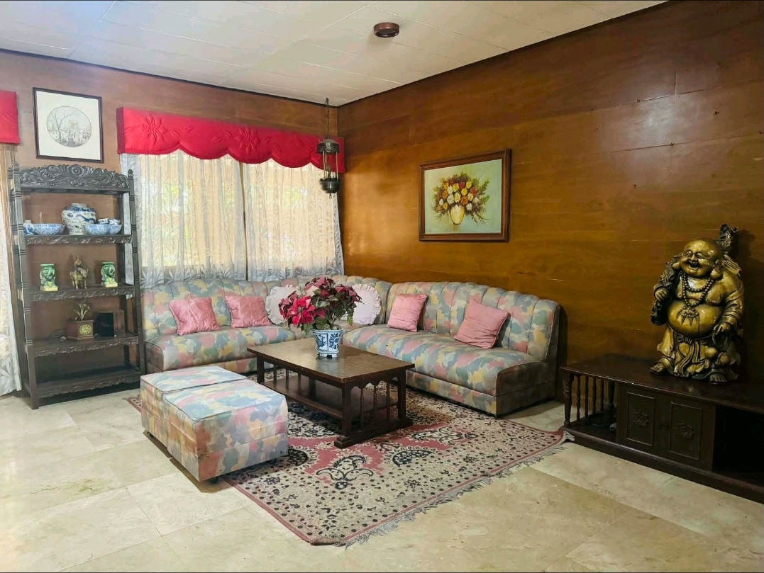 Wood-panelled living room with classic furniture, formal seating, and warm timber walls