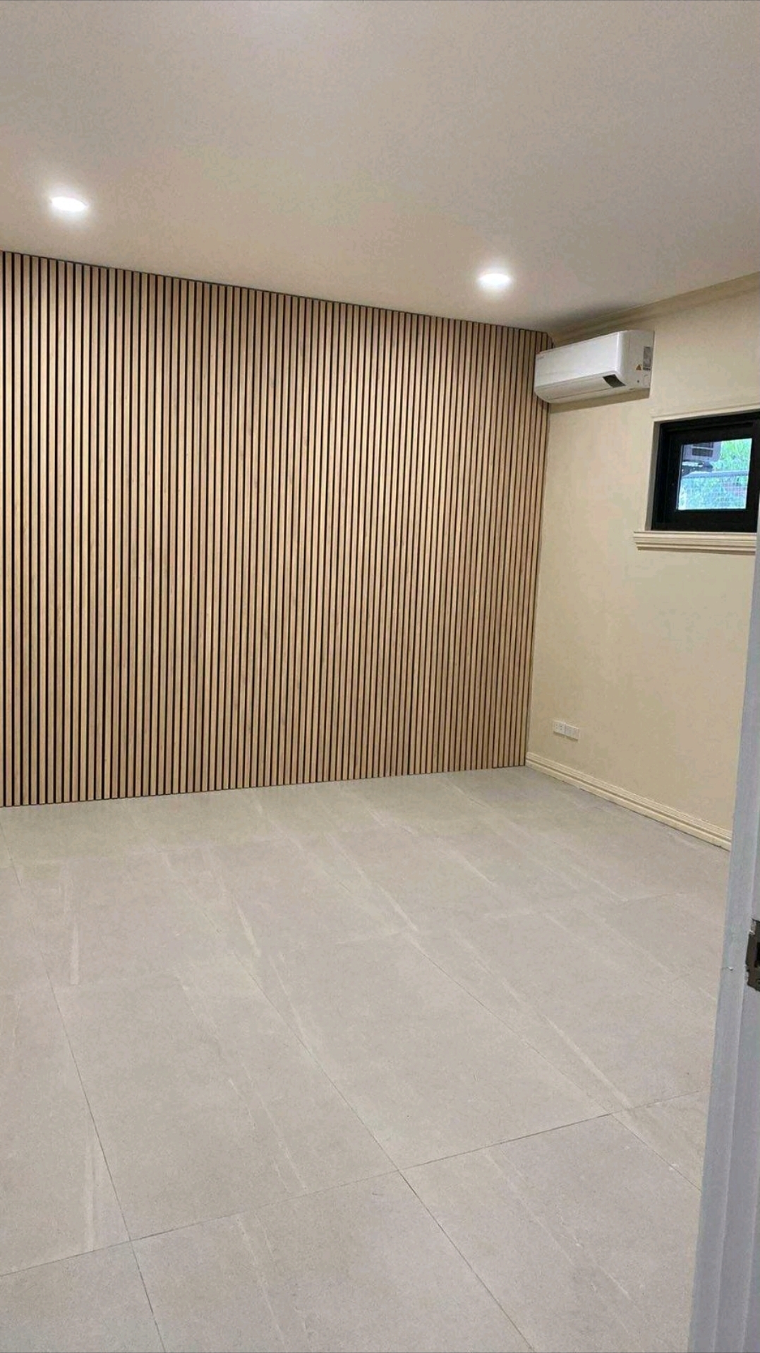Bedroom with wood slat feature wall and split-type air conditioning