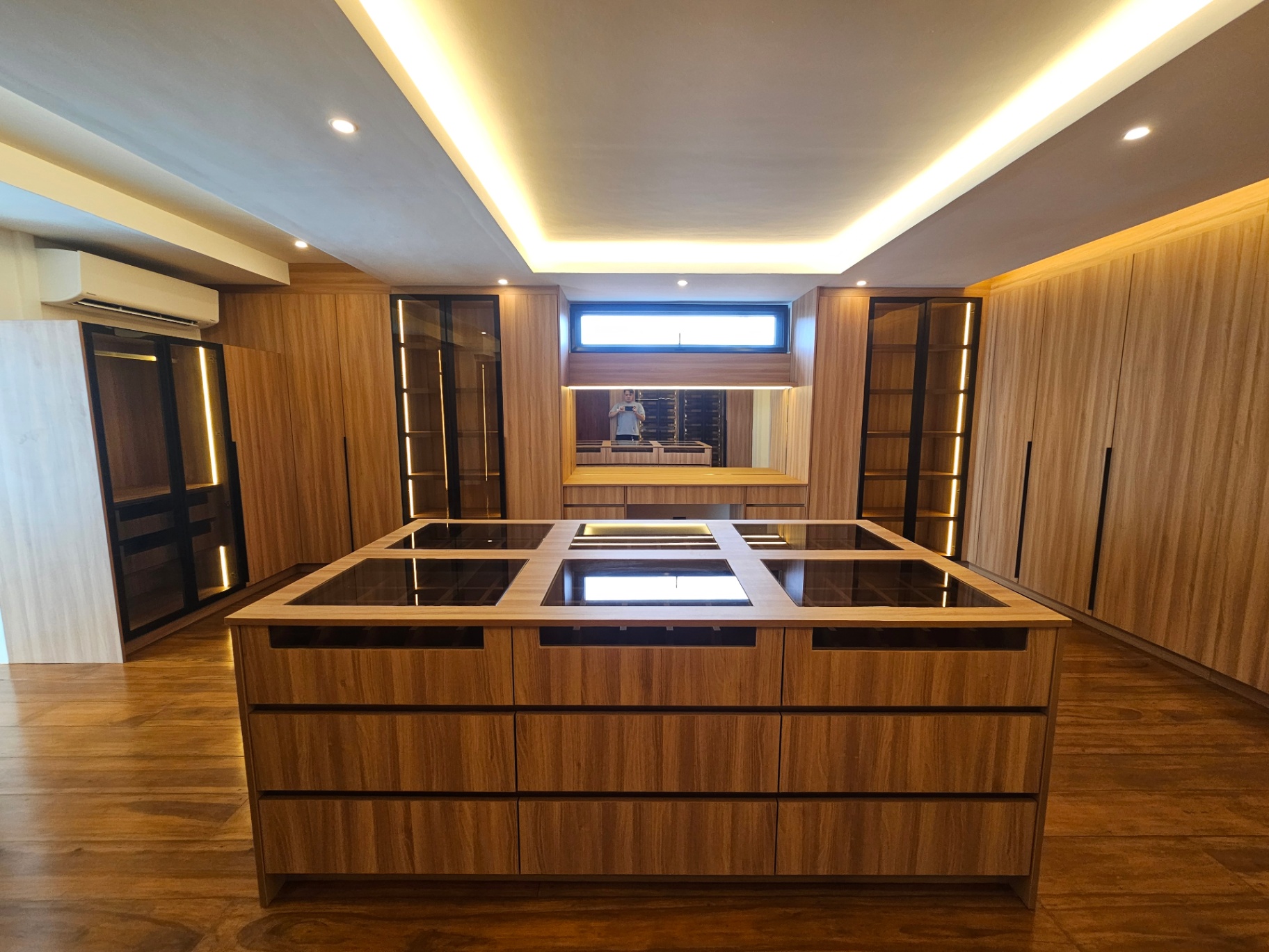 Spacious wood-finished walk-in dressing room with island