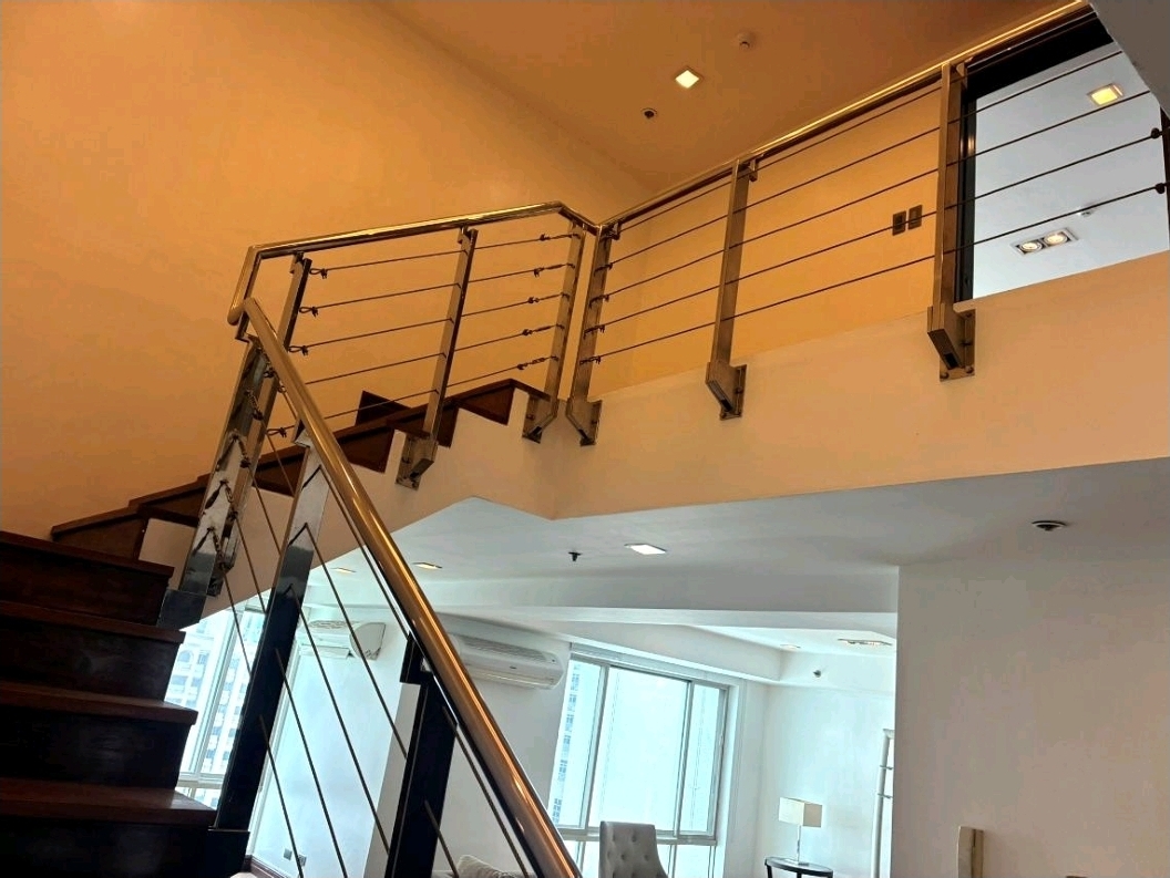 Double-height interior with loft-level walkway and glass railing