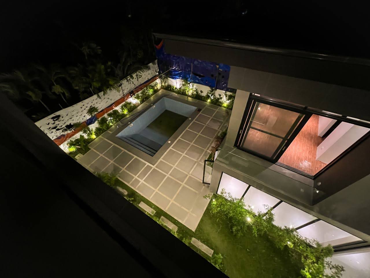 High-angle view of the pool and courtyard at night
