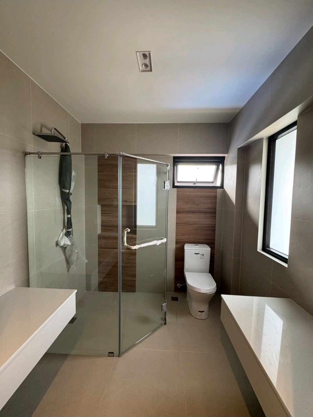 En-suite bathroom with rain shower, glass enclosure, wood accent tile and floating vanity