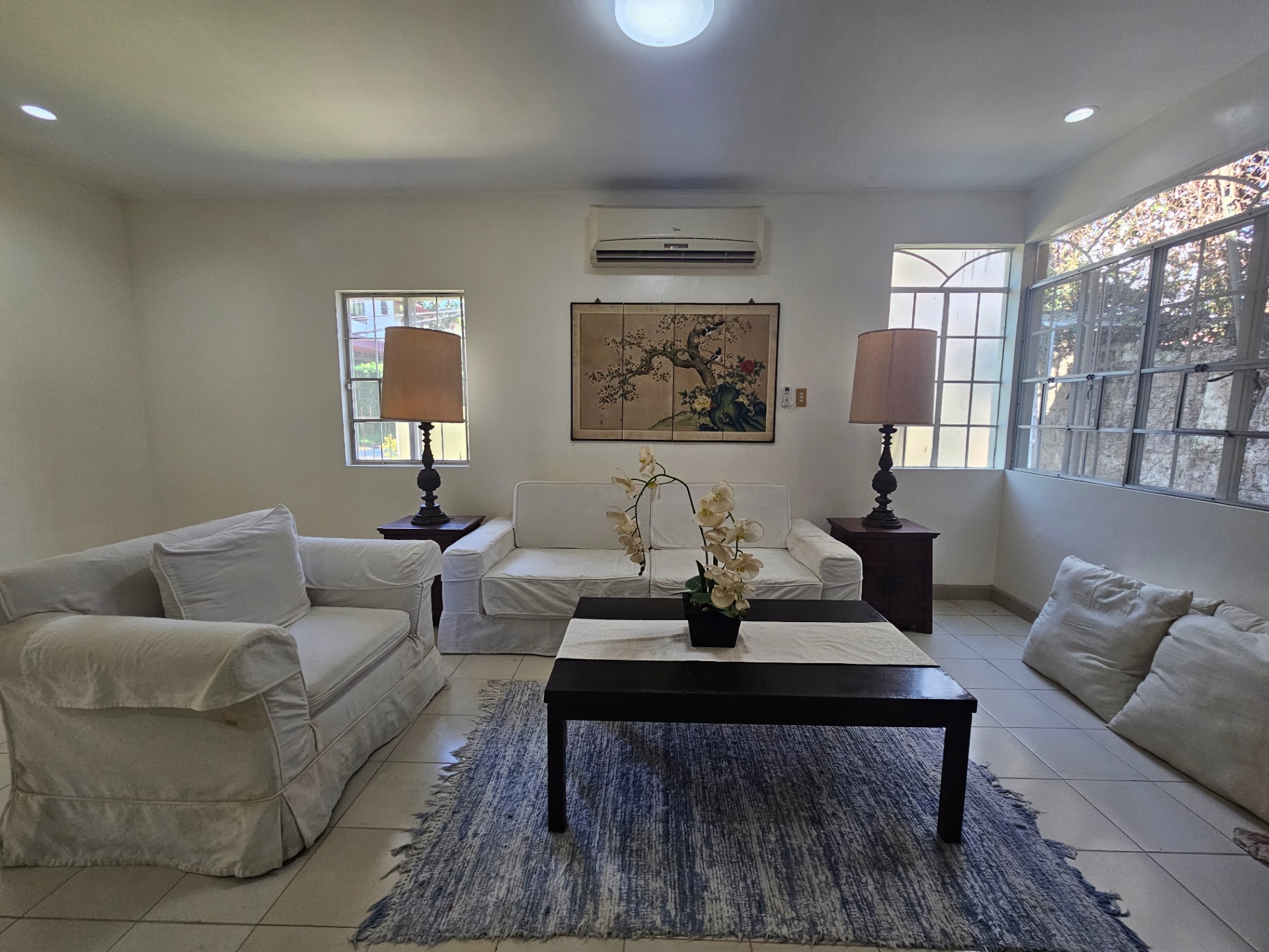 Sun-filled living room with garden-view windows and coffee table
