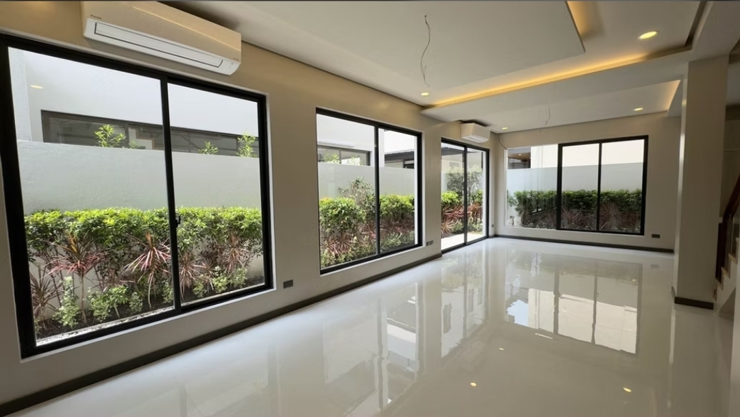 Dining area with wraparound black-framed windows overlooking the garden