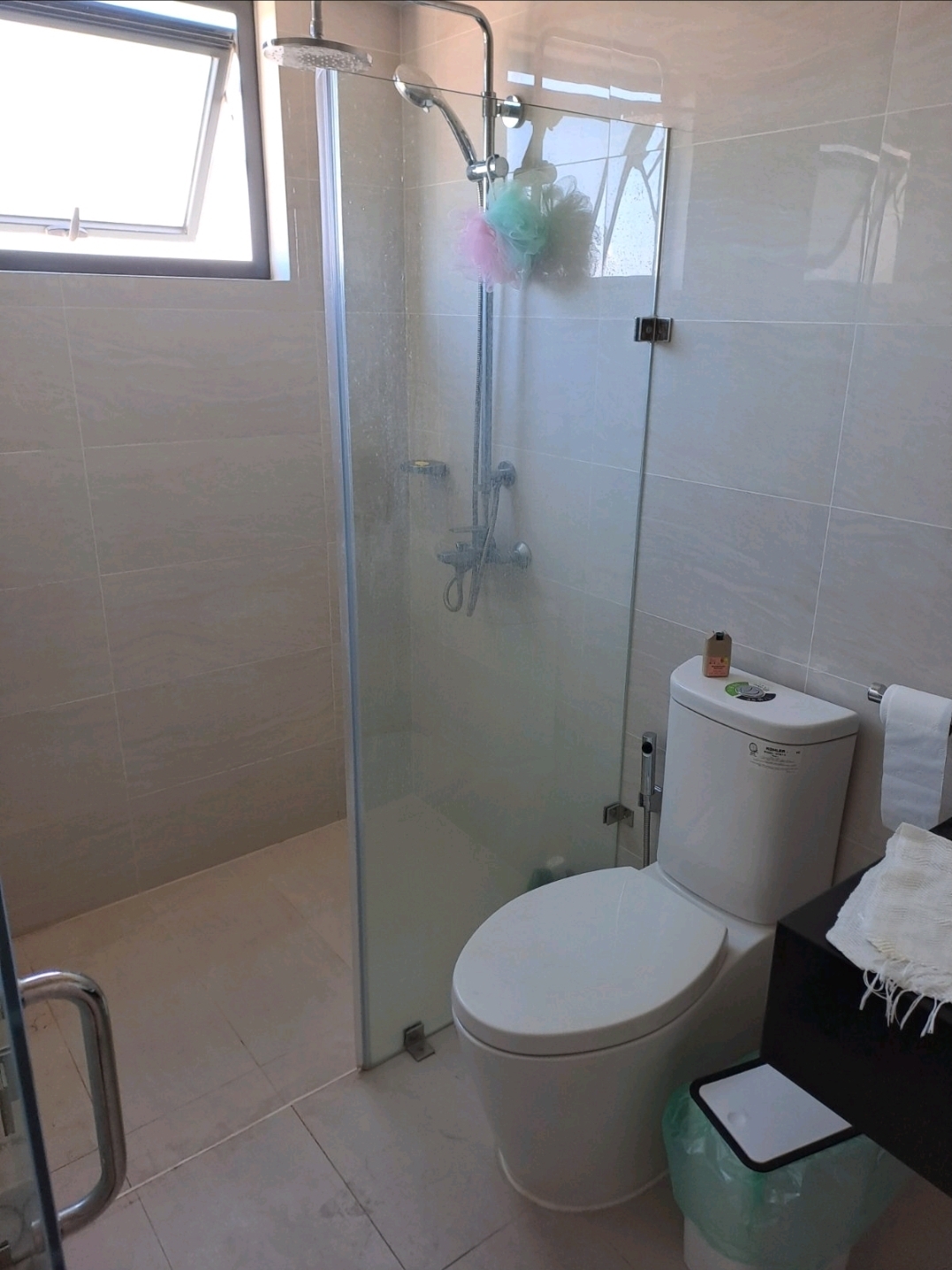 Shared toilet and bath with modern fixtures and tiled flooring