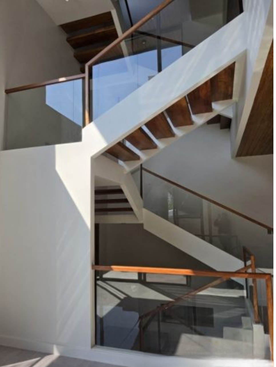 Floating open-riser staircase beneath a soaring hardwood ceiling