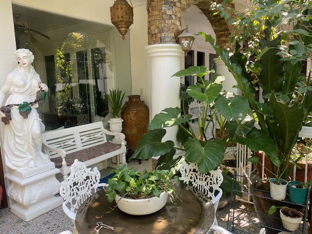Garden nook with classical statuary, bench and lush plants