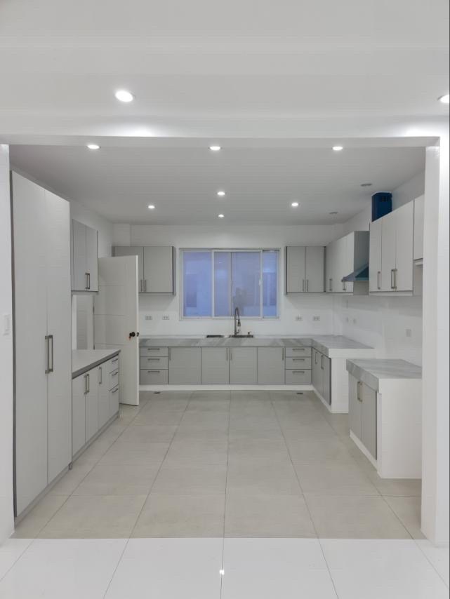 Spacious service kitchen with full grey cabinetry and range hood