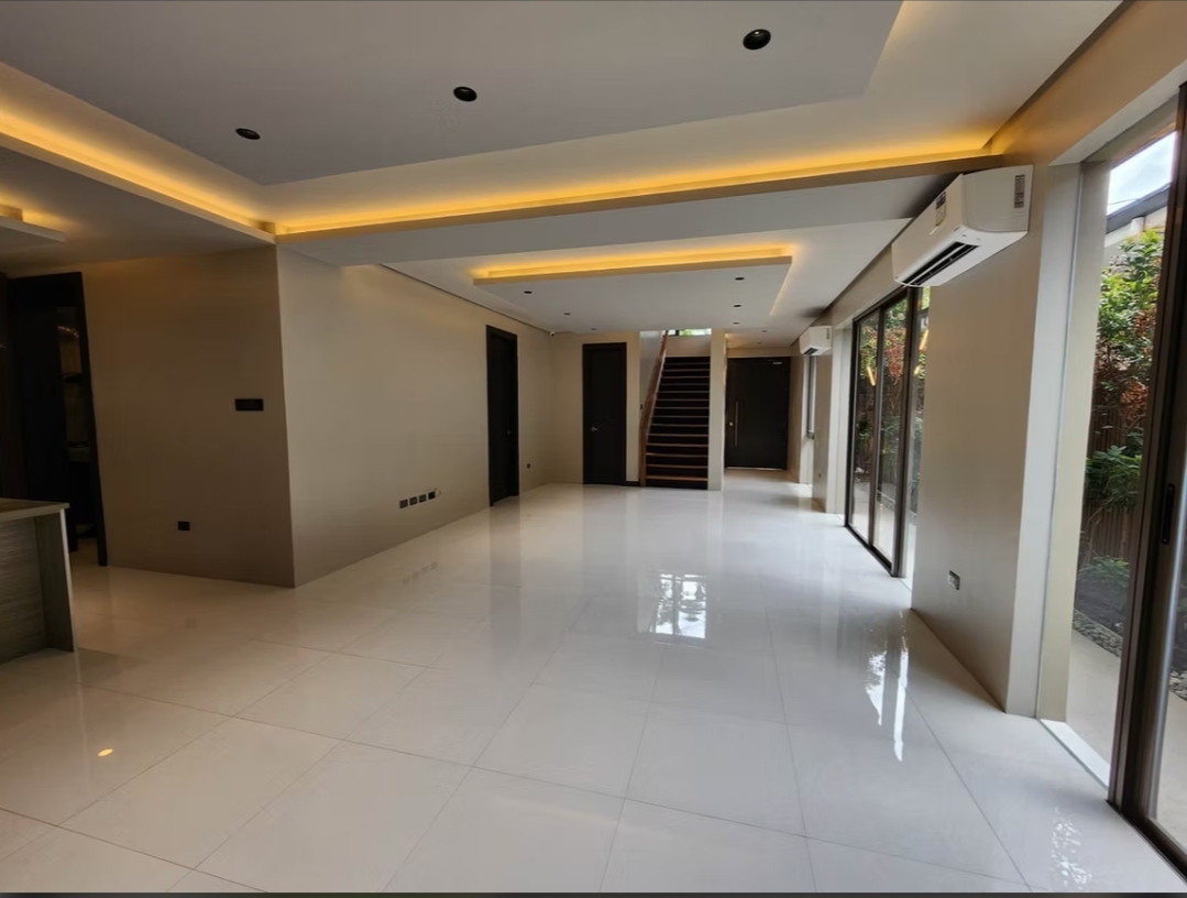 Wide great room with staircase and garden-facing glass walls