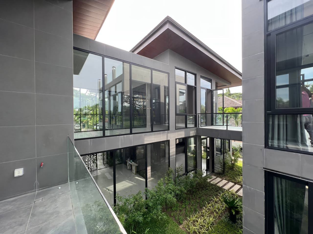 Grey-tiled exterior volume with glazed walkway