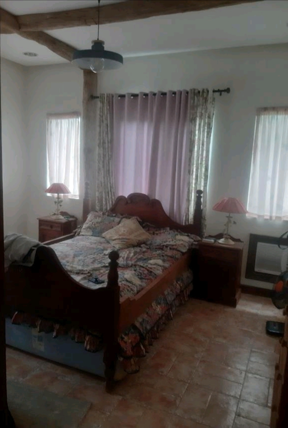 Bedroom with narra tile flooring, curtained window and warm ceiling beam