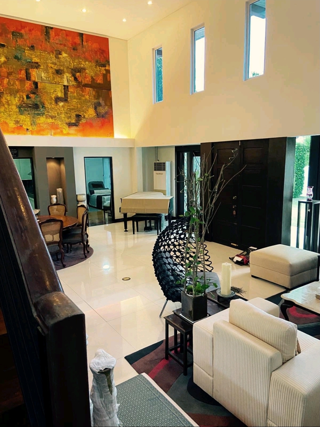 Grand living and dining hall with soaring ceilings and abstract art