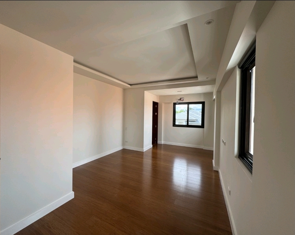 Bedroom with warm bamboo hardwood flooring, cove ceiling and picture window