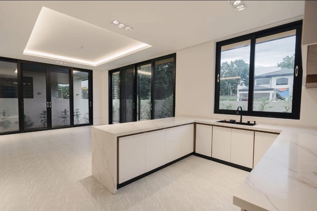 Second kitchen area with L-shaped marble counters and garden windows