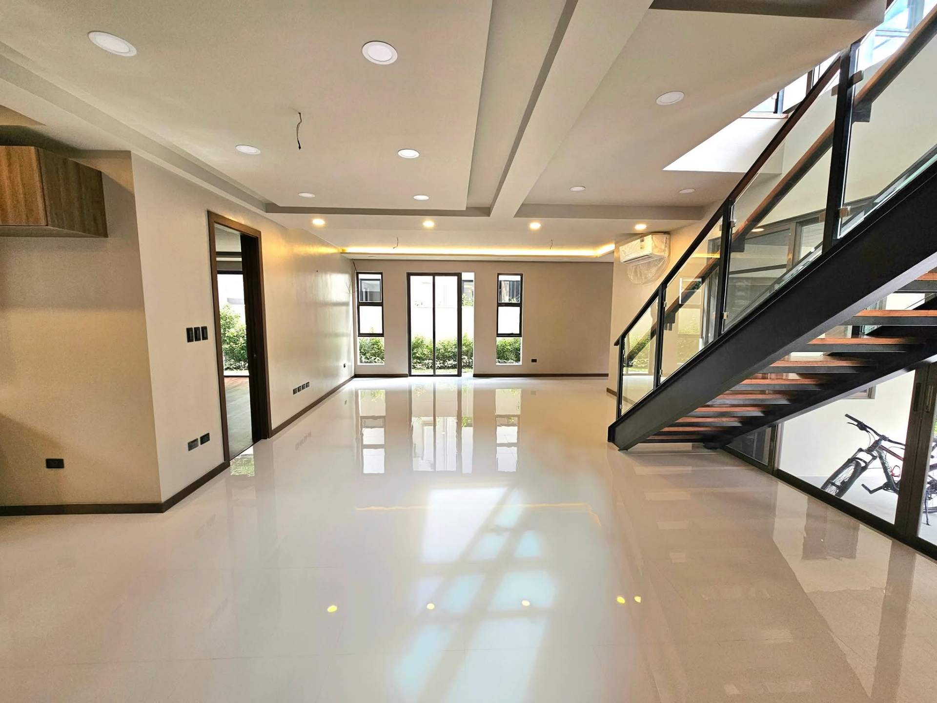 Open great room with floor-to-ceiling windows and garden views