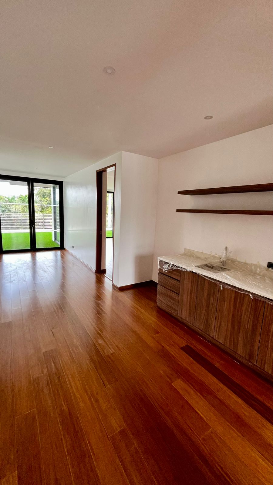 Pantry area with custom hardwood cabinetry, stone countertop, and floating shelves