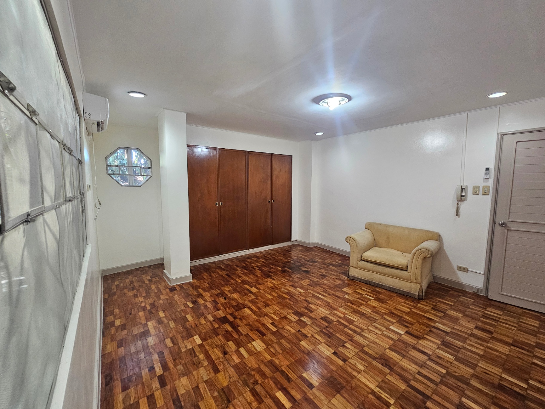 Living area with built-in wood closet and parquet flooring