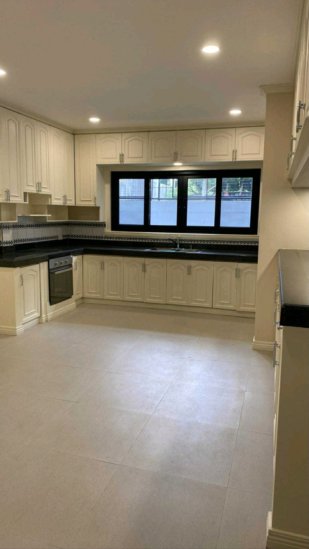 Large main kitchen with extensive cabinetry and black stone counters