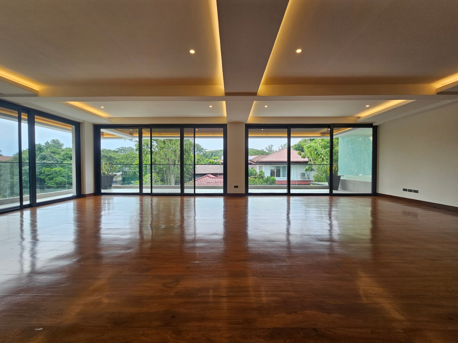 Grand living room with dramatic coved ceiling lighting and panoramic glass doors