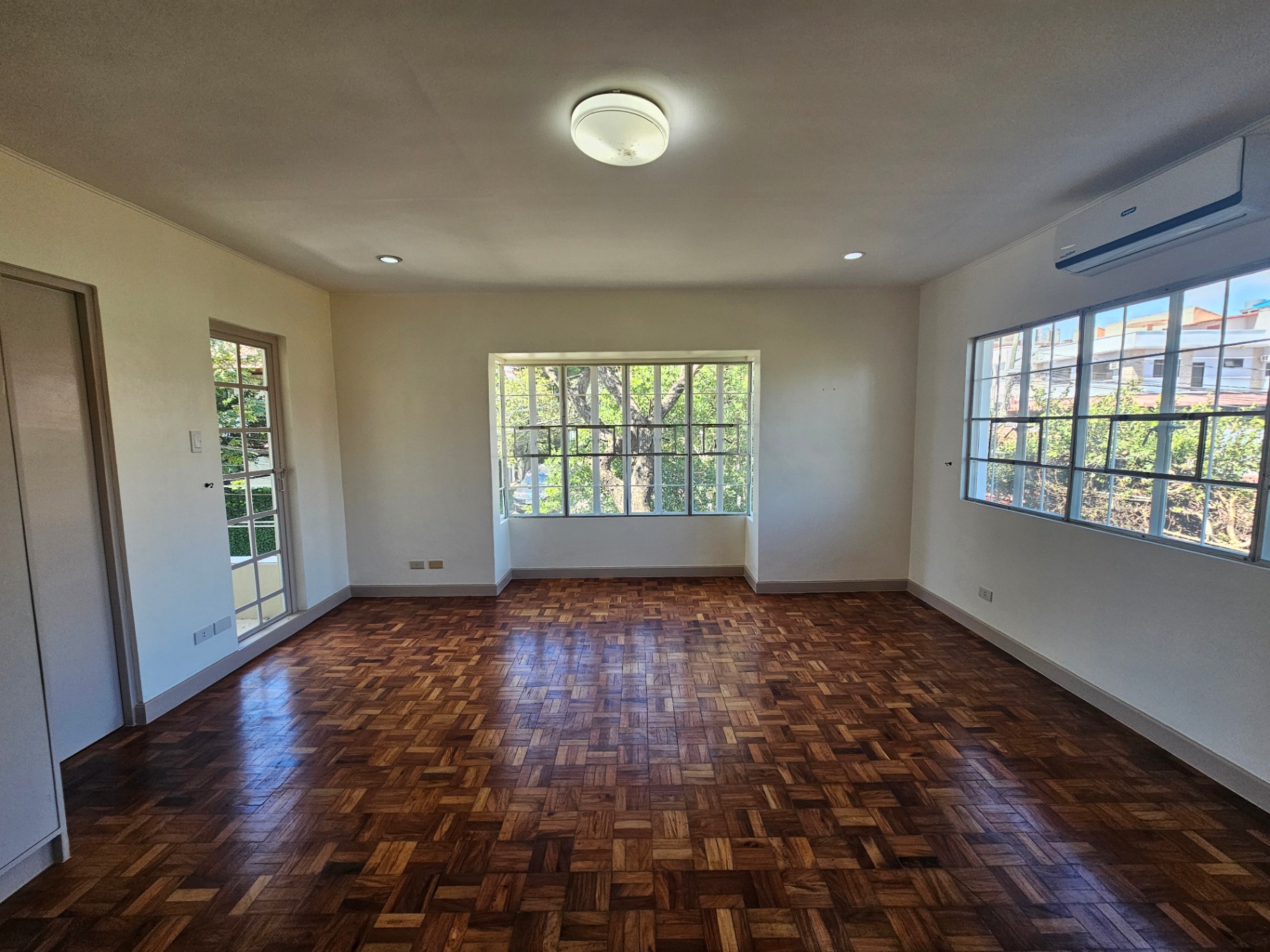 Spacious living room with herringbone parquet floors and garden doors
