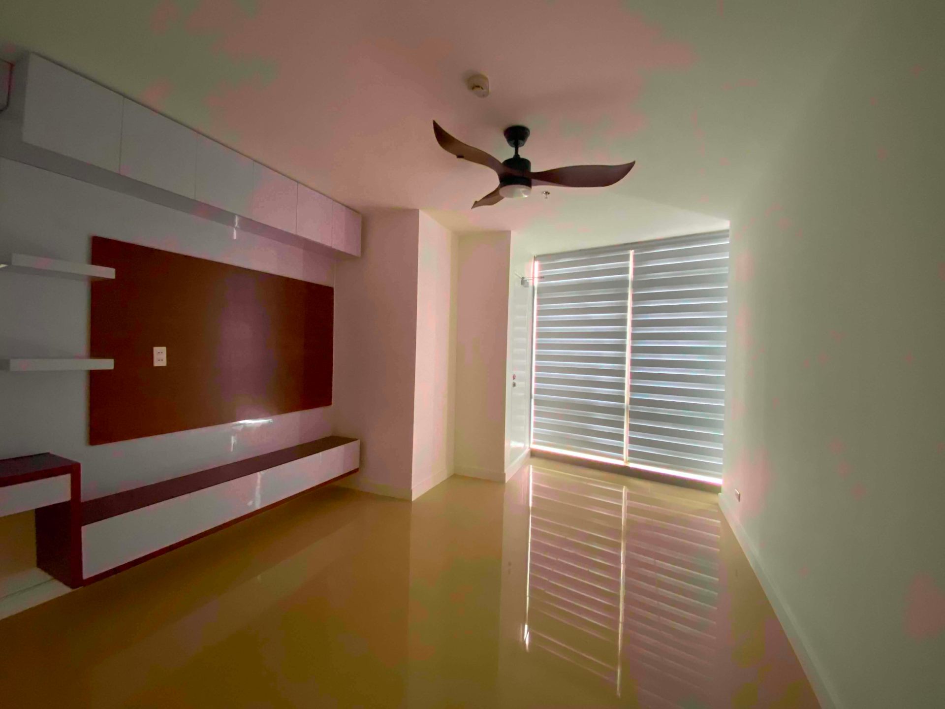 Den area with feature wall, floating shelves, and ceiling fan