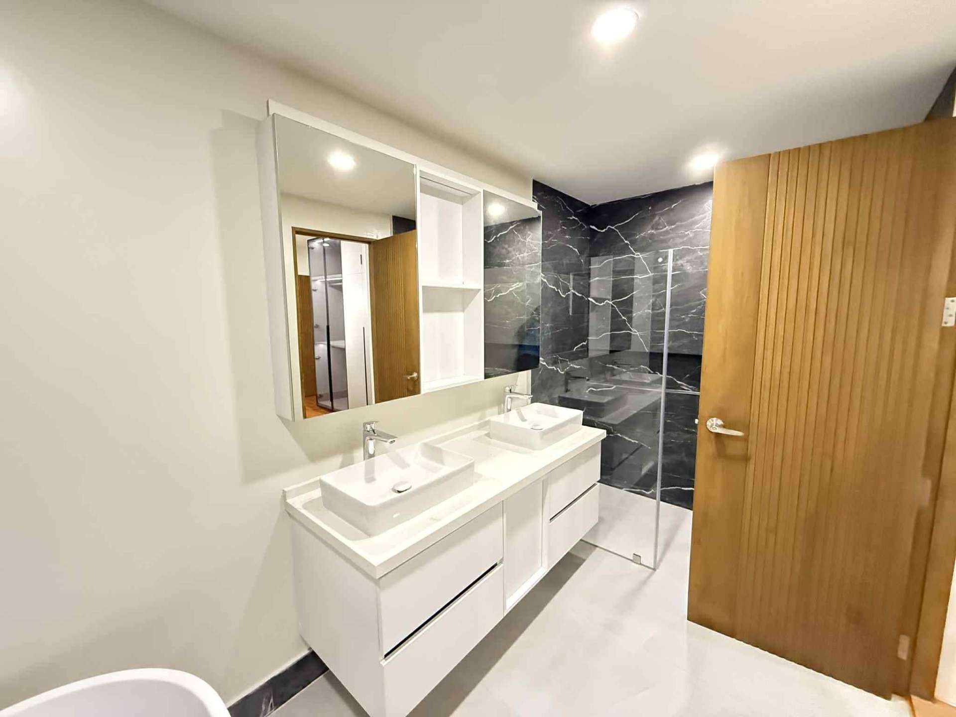 Spacious bathroom with double vanity, large mirror, and walk-in shower