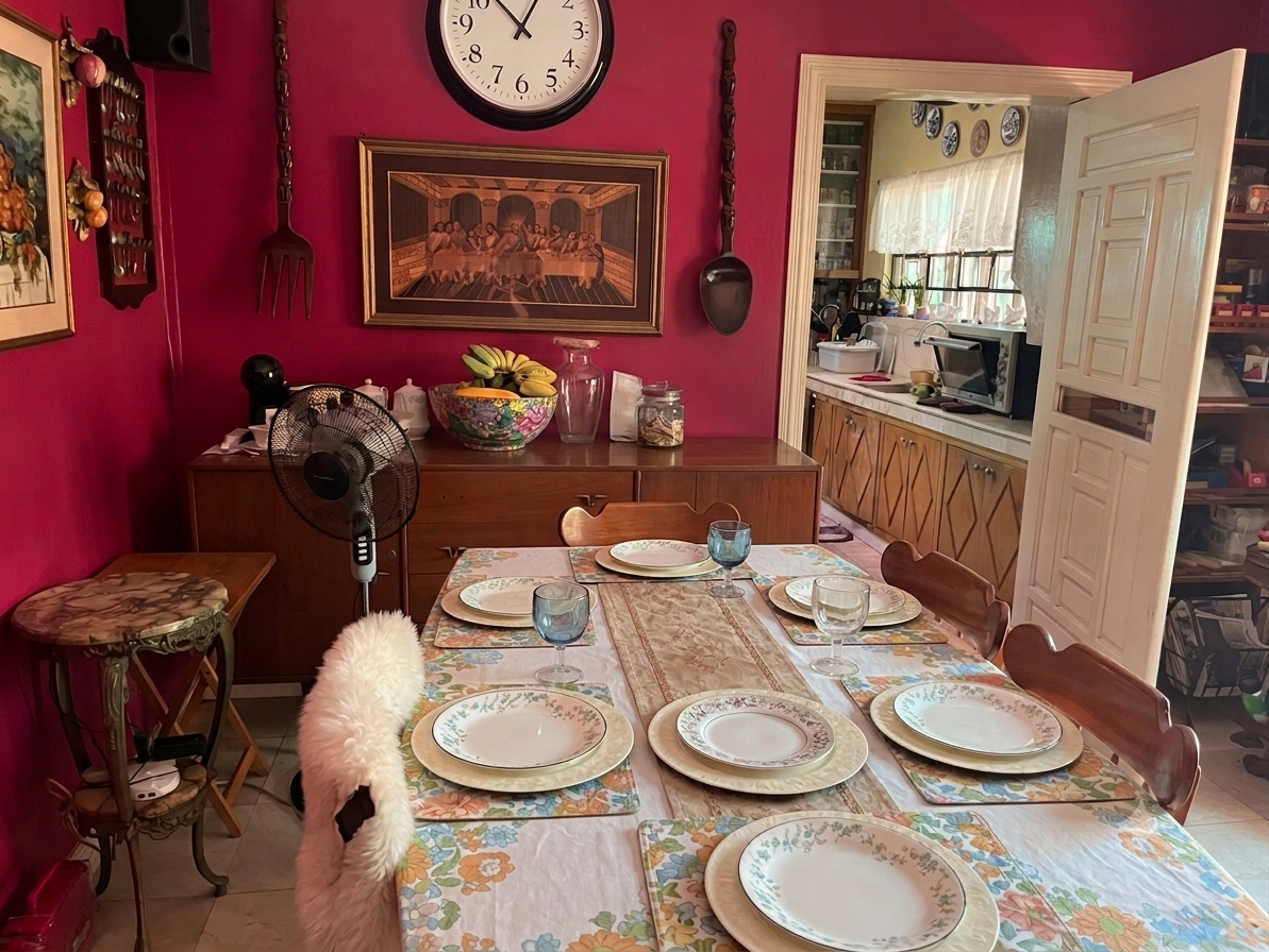 Formal dining area with rich red walls opening toward the kitchen