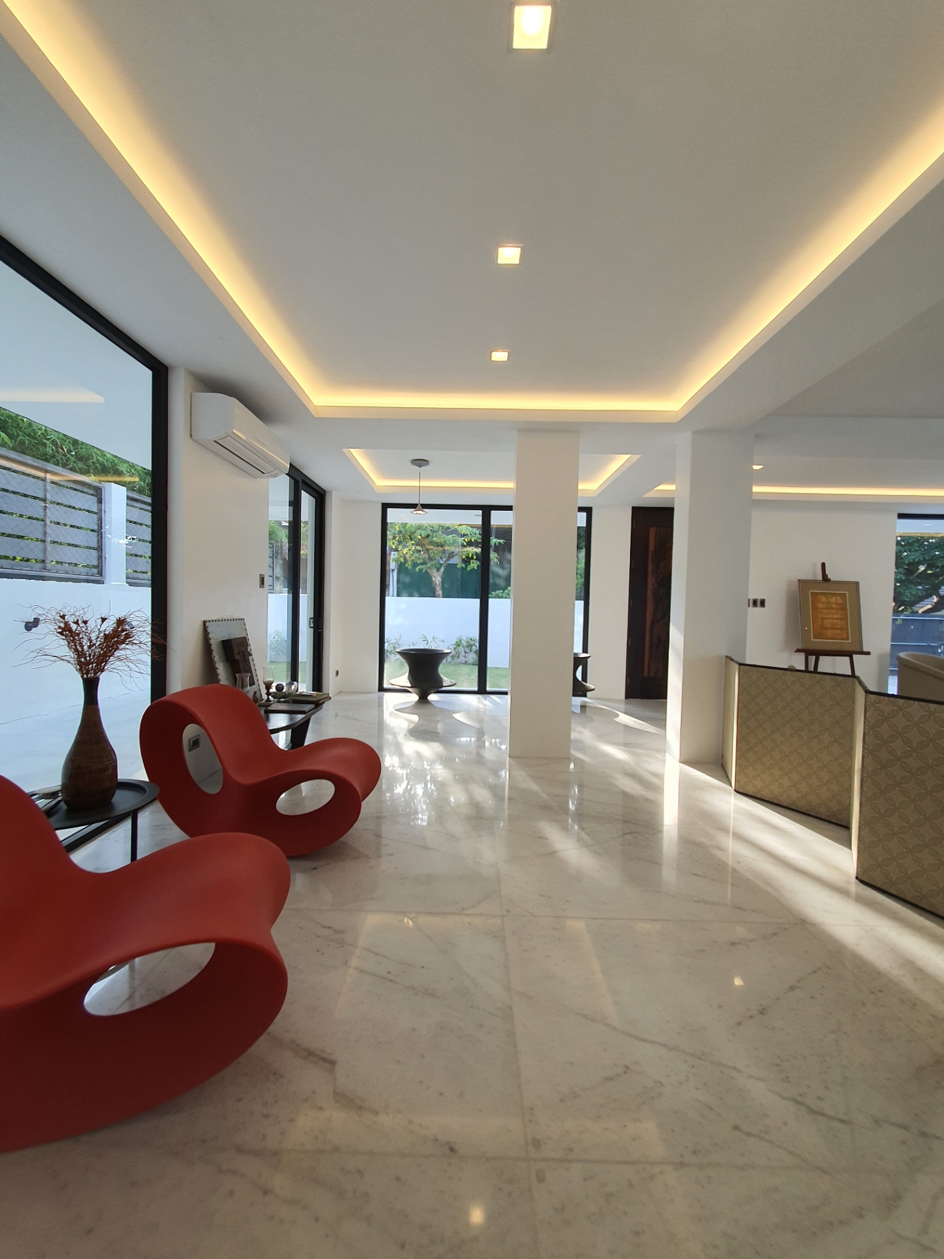 Light-filled lounge with floor-to-ceiling windows and garden views