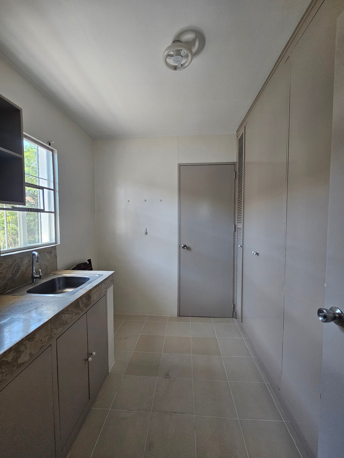 Service kitchen with stone counter and garden-view window