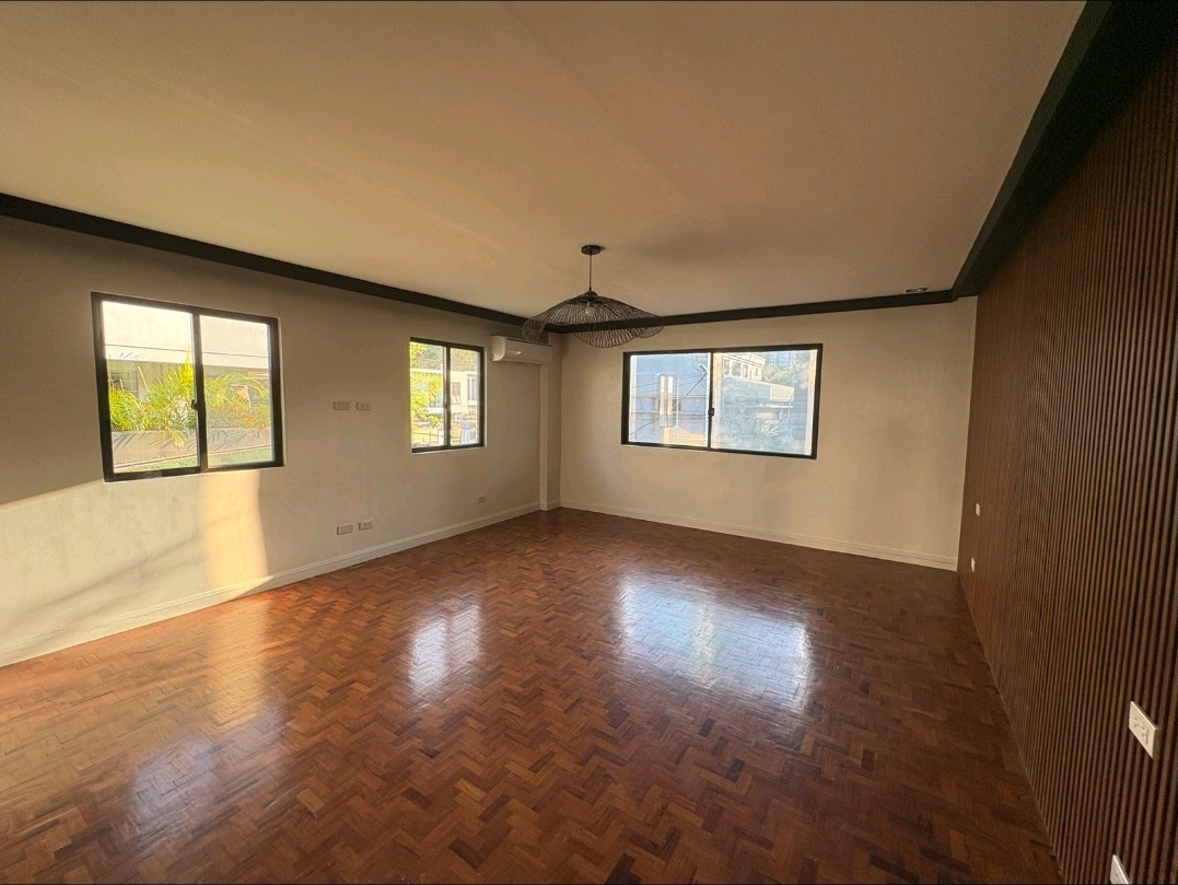 Bright living area with parquet flooring and triple windows