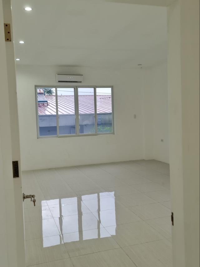 Clean bedroom with split-type air conditioning and large window