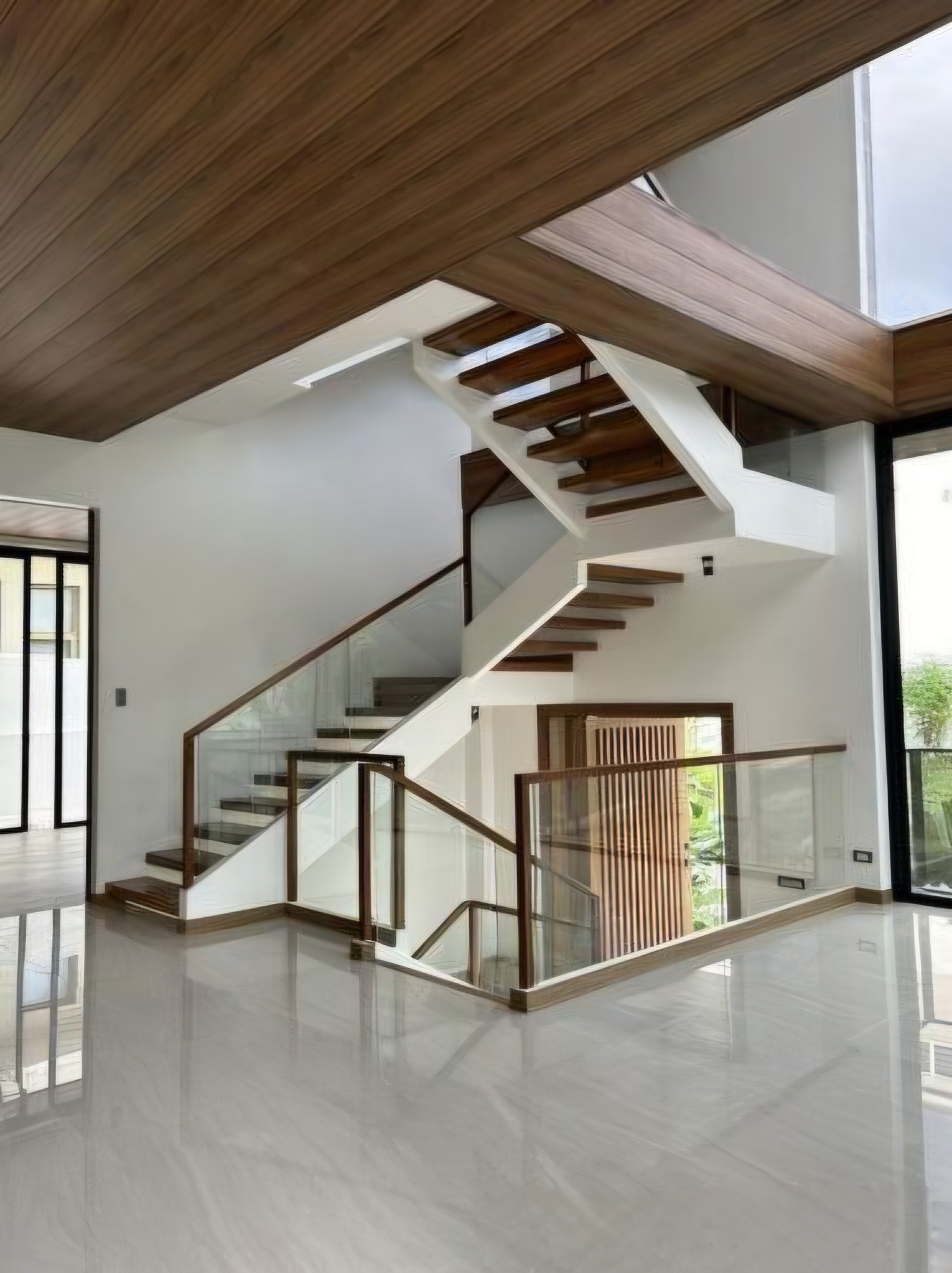Floating open-riser staircase beneath a soaring hardwood ceiling