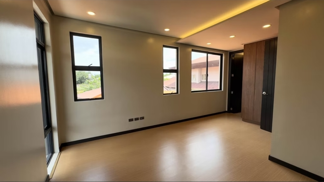 Bedroom with wood-look flooring, multiple windows and cove lighting
