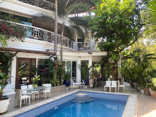 Swimming pool and lanai wrapped by tropical garden