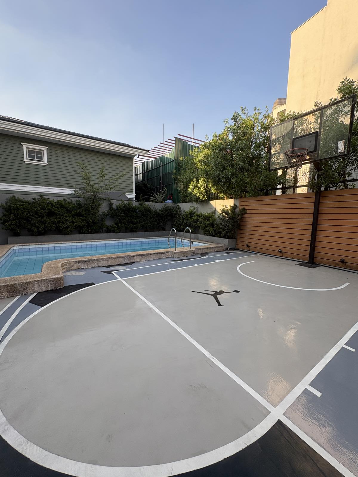 Pool and basketball court with hoop and wood fence