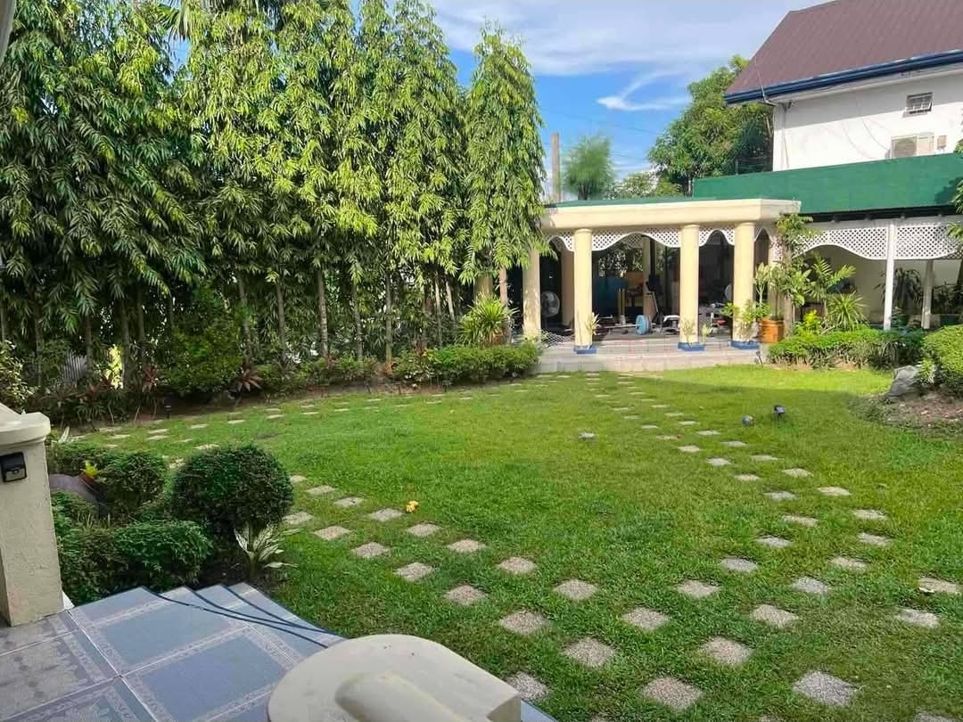 Landscaped garden with colonnaded lanai pavilion and checkered stone walkways
