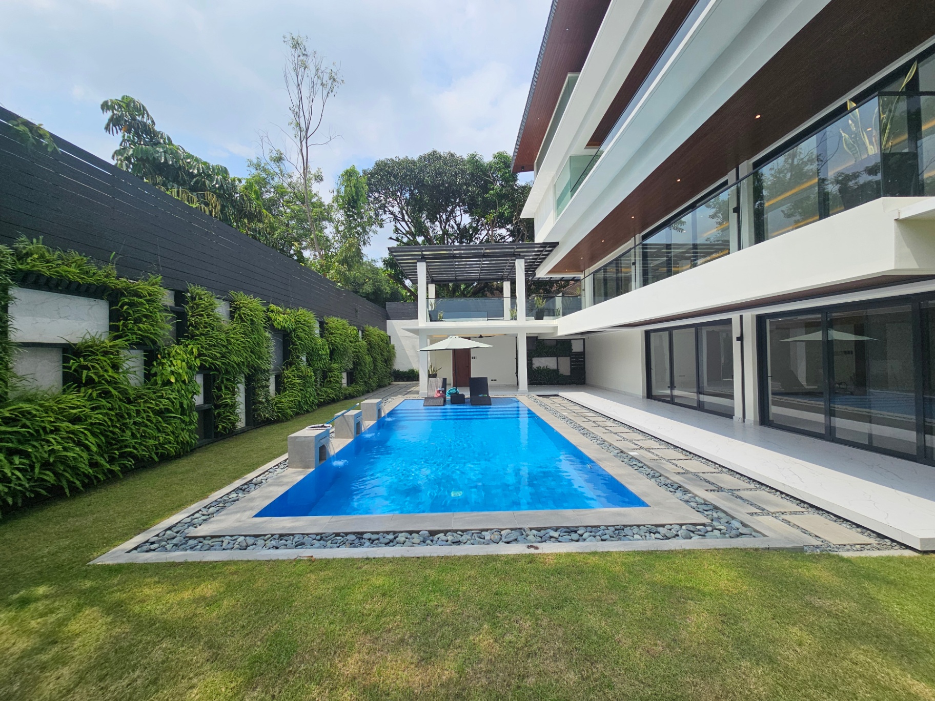 Side view of the pool framed by vertical garden walls and lawn