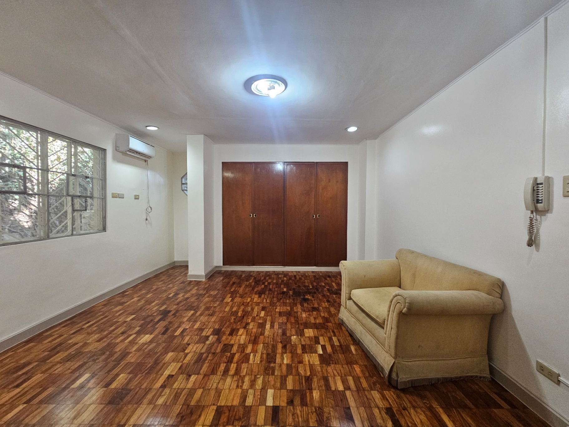 Air-conditioned bedroom with parquet wood flooring and built-in wardrobe