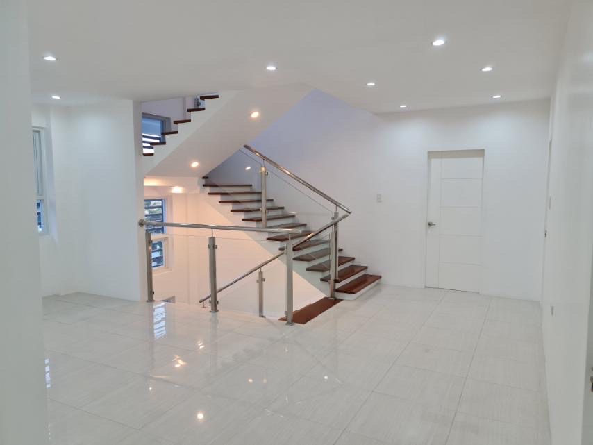 Stainless and glass railed staircase with wood treads in a bright open hall