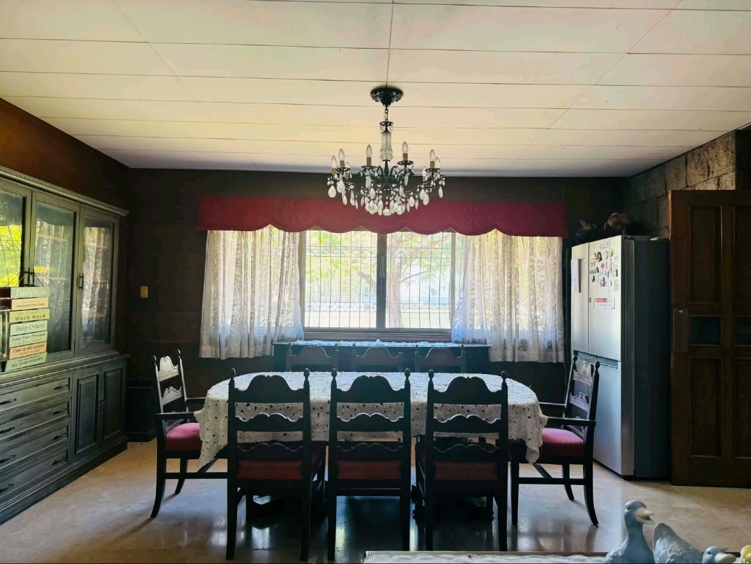 Formal dining room with a crystal chandelier and large garden-facing windows