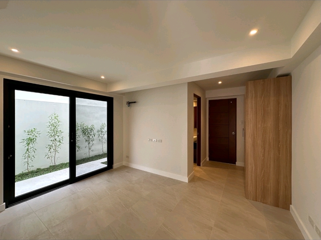 Ground-floor bedroom with full-height sliding doors opening to a private landscaped side garden