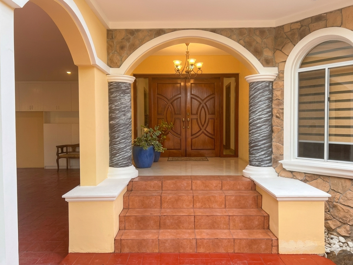 Main entrance with stone walls, double doors, and cylindrical pillars