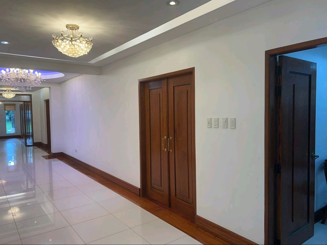 Interior hallway with chandeliers and wood-trimmed doors