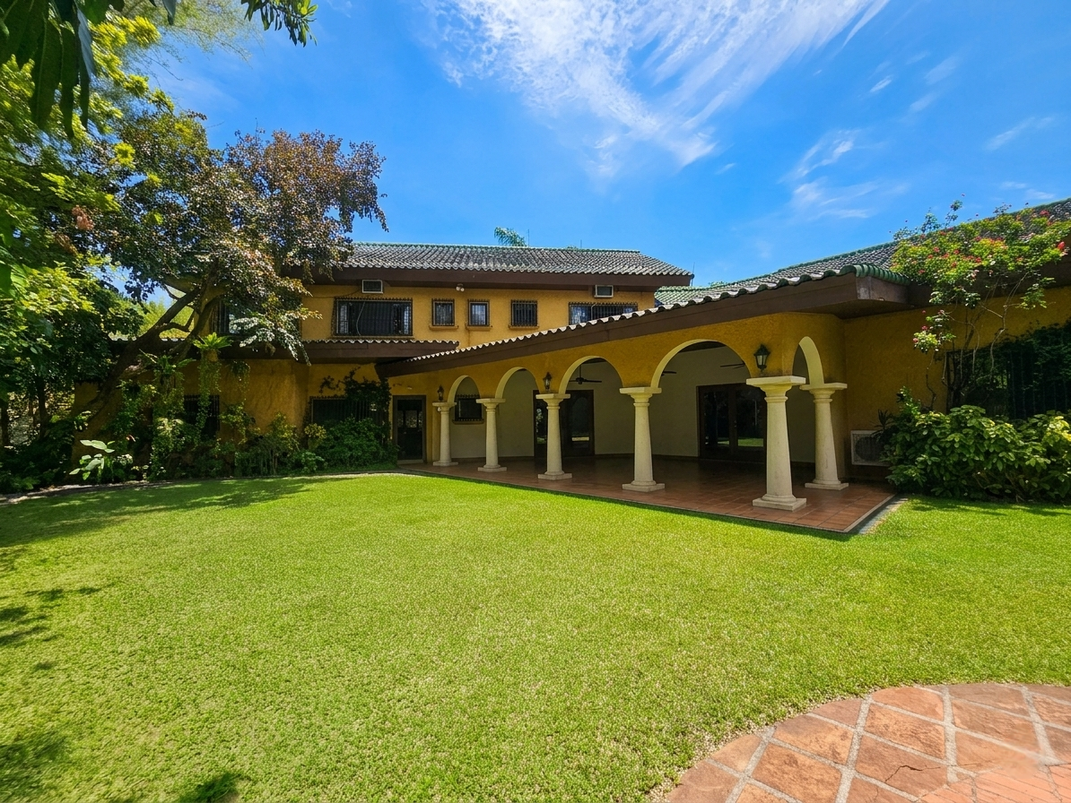 Mediterranean rear facade with arched lanai opening to the lawn