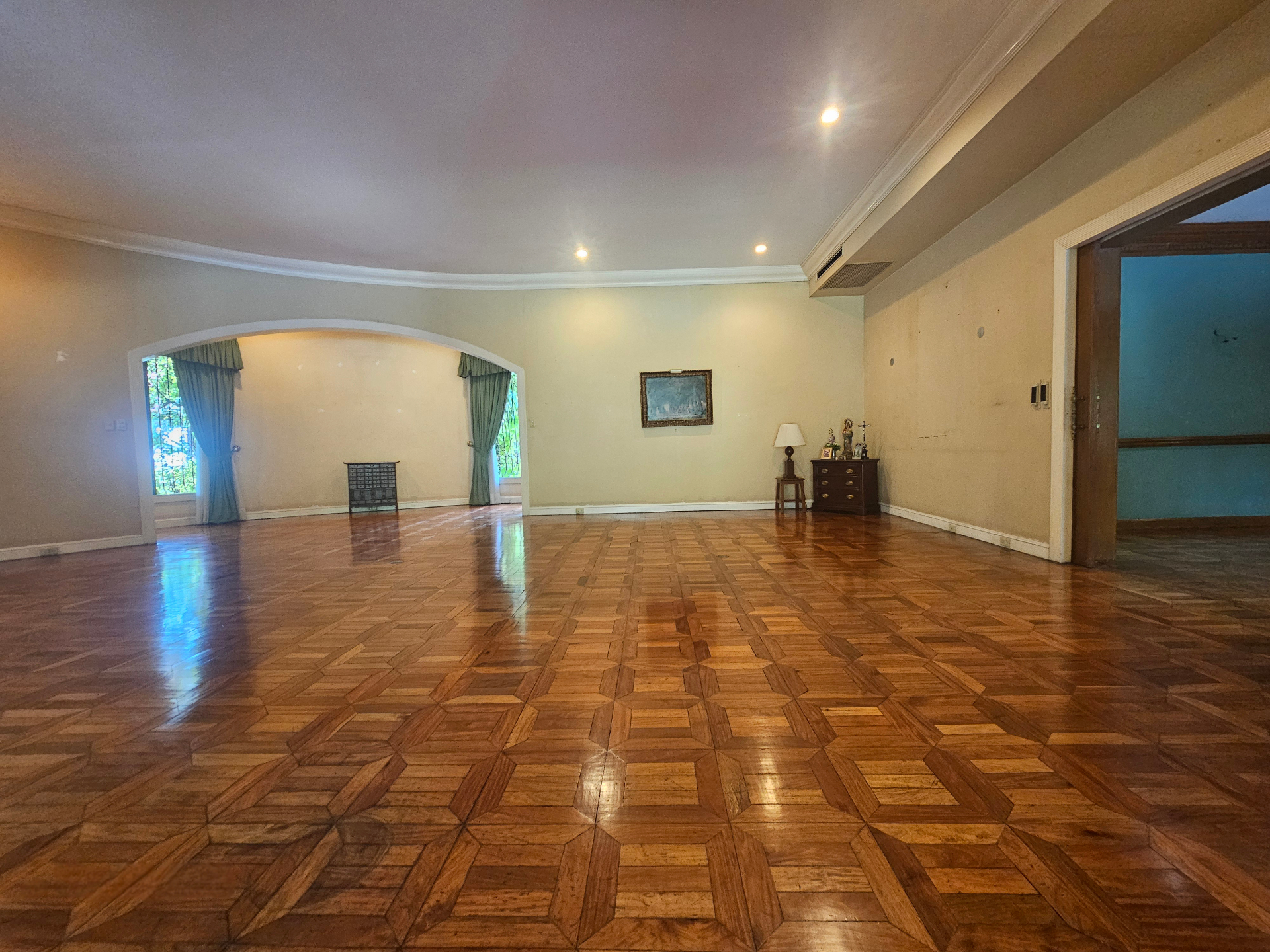 Formal living salon with parquet floors and arched opening