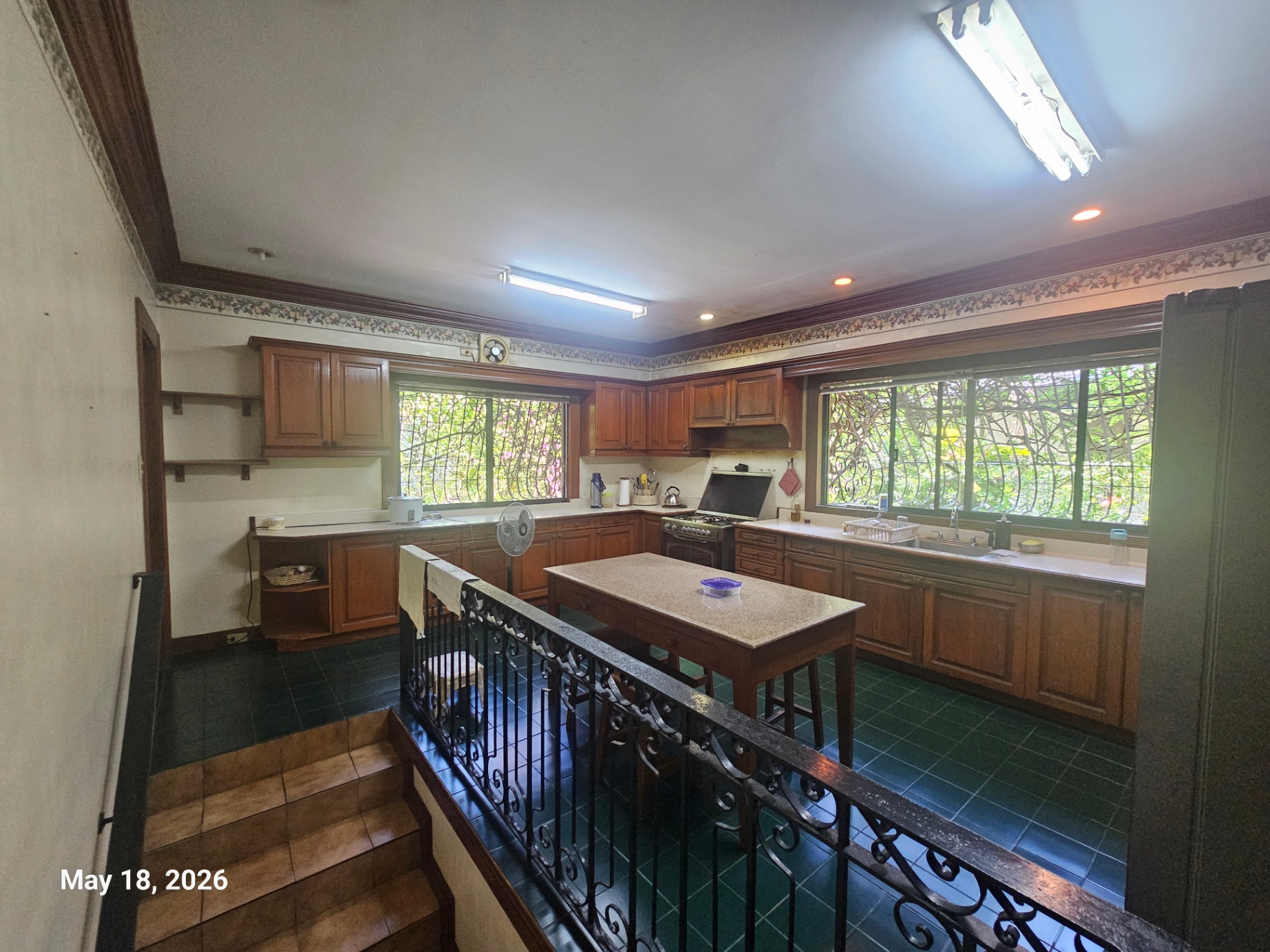 Main kitchen with central island, elevated layout, and garden windows