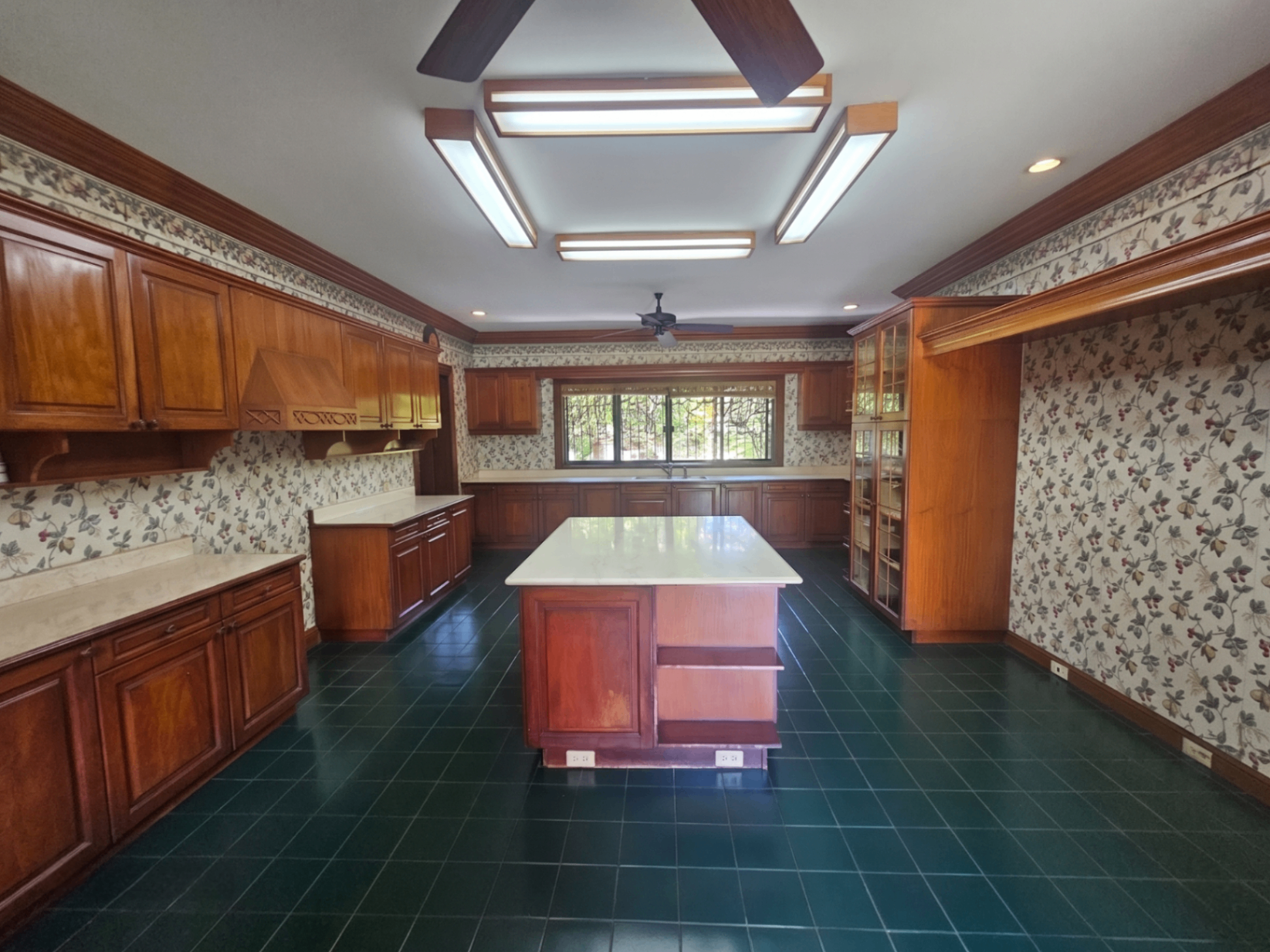 Expansive chef's kitchen with marble-topped island and rich wood cabinetry