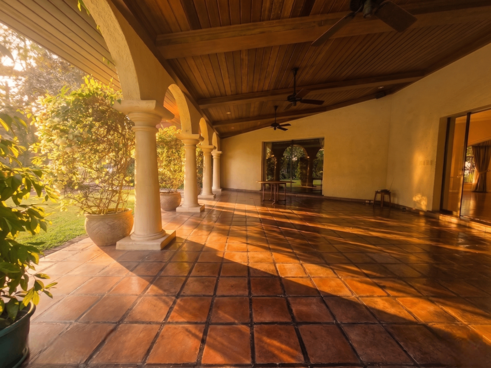 Golden-hour view of the colonnaded lanai opening to lush tropical grounds