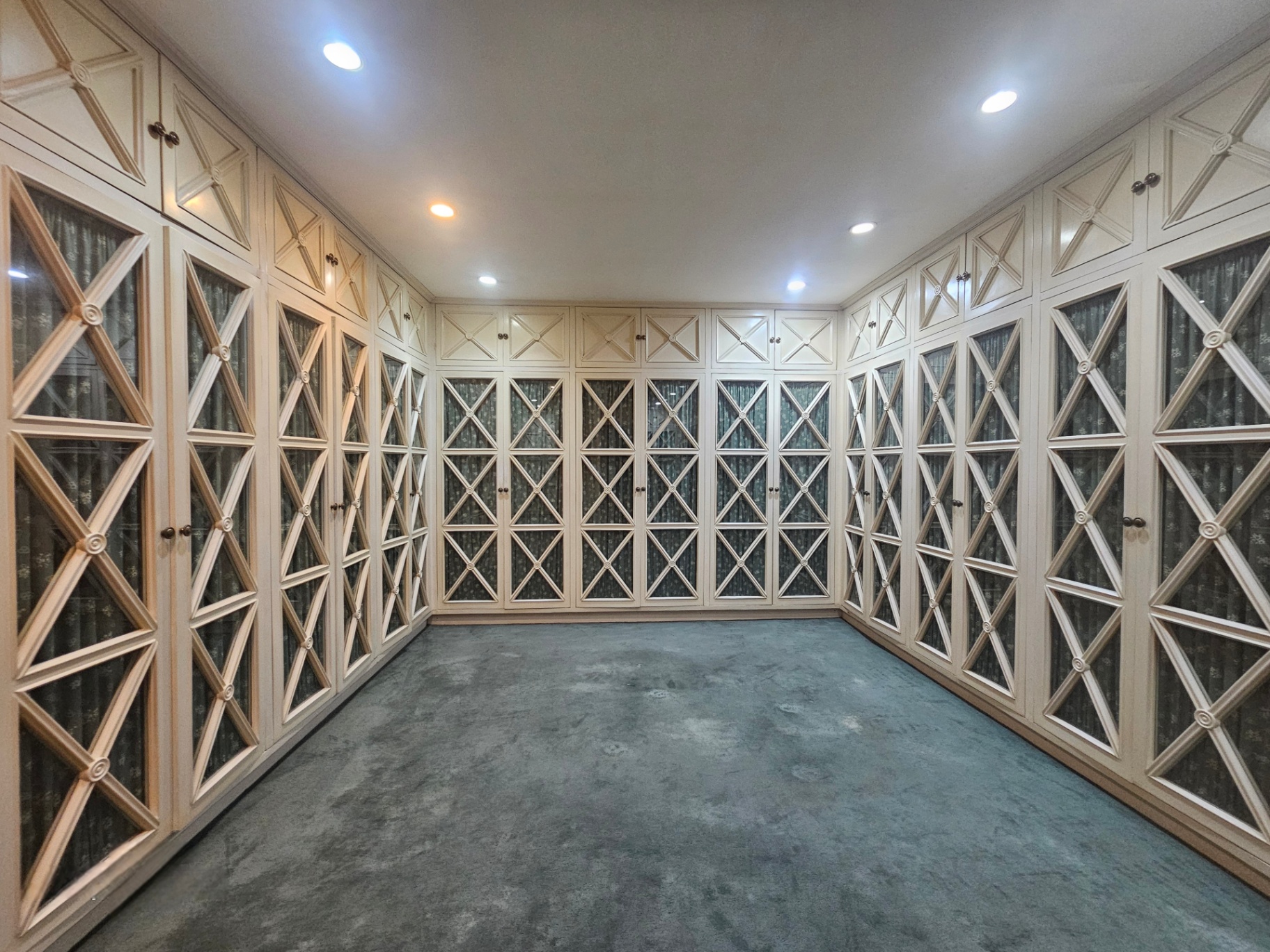 Generous walk-in dressing room with custom lattice-front cabinetry